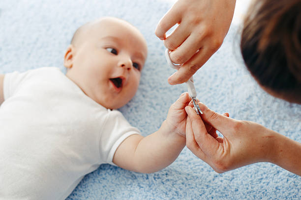 Mother cutting babies nails